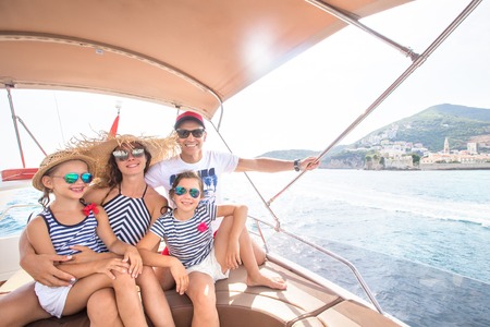Happy family with children enjoy relaxing on a yacht at seaの写真素材