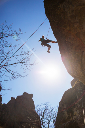 Woman  climbing  on rock  in the mountains. Silhouetteの写真素材