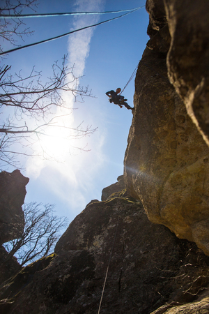 Man  climbing  on rock  in the mountains.  Silhouetteの写真素材
