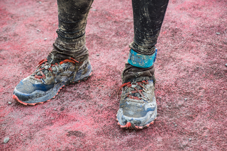 runner's feet in sneakers after running in the mudの写真素材