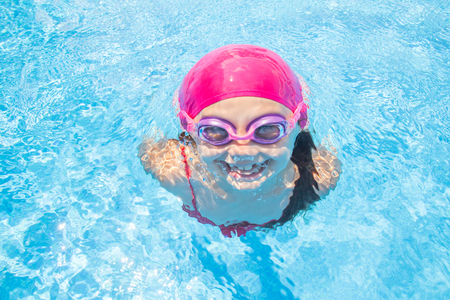 little girl deftly swim underwater in poolの写真素材