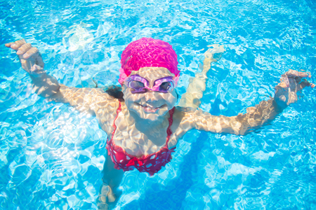 little girl deftly swim underwater in poolの写真素材