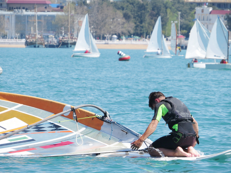 young gayl sitting on windsurfing in seaの写真素材