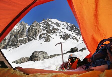 view of the snowy mountains from the tent with an ice ax