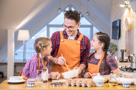 Father with little  children have cooking together in the kitchen at homeの写真素材