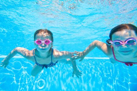 little kids swimming  in pool  underwater.の写真素材