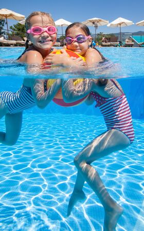 little girls swim on an inflatable mattress in the poolの写真素材