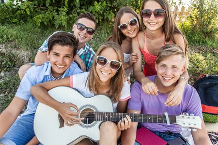 group of teenagers spending time together with guitar