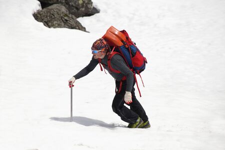 man mountaineer with ice ax climbs on the  snowy mountainsの写真素材
