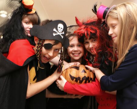 group of funny children in costume celebrate together a halloween partyの写真素材