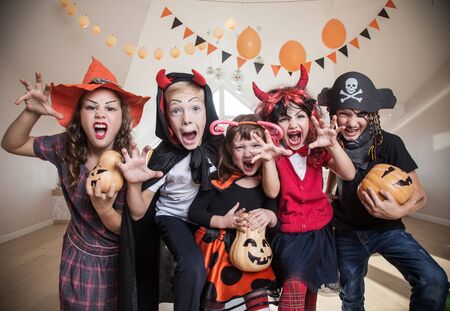 group of funny  children in costume celebrate together a halloween partyの写真素材
