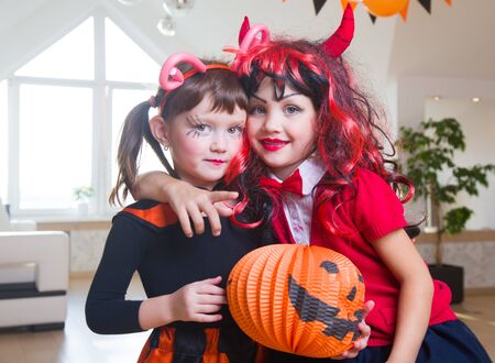 little girl in costumes with pumpkins for Halloween celebrationの写真素材
