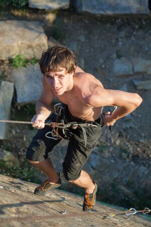 young man climbing on the rockの写真素材