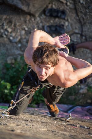 young man climbing on the rockの写真素材