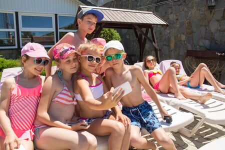 Children make selfies on the phone at a summer resortの写真素材