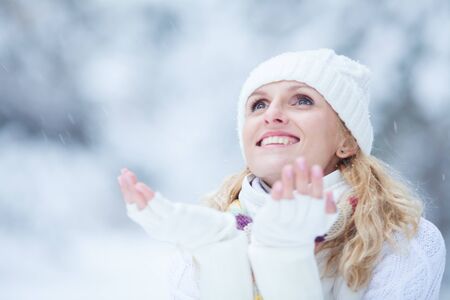 laughing young woman playing in the snowの写真素材