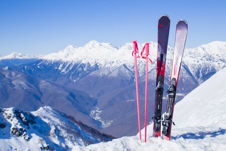 mountain skiing set standing in the snow against the backdrop of the beautiful snow-capped mountainsの写真素材