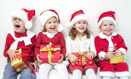 Group of four children in Christmas hat with presentsの写真素材