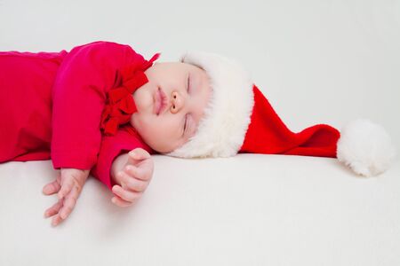 Cute baby in Santa hat is sleeping in Christmas nightの写真素材