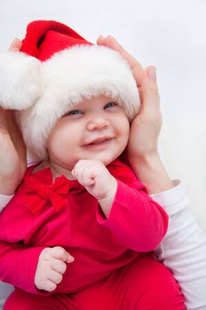 Mother holding  her baby daughter in Santa hatの写真素材