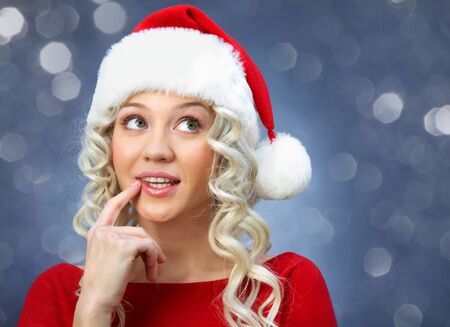 beautiful young blonde girl in santa claus hat smiles for christmas card.の写真素材