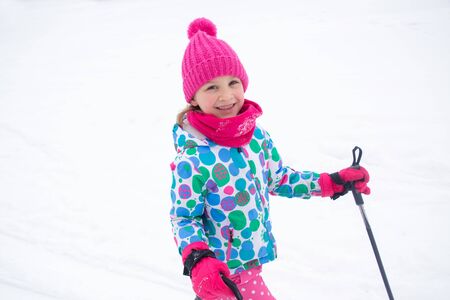 Portrait of a sporting little girl in equipment at a ski resortの写真素材