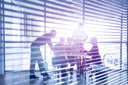 Group of silhouettes of businesspeople interacting  background business centreの写真素材