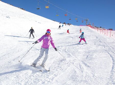 woman skiing on a snowy road in the mountainsの写真素材