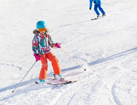 little girl on alpine skiing skating on slope in ski resortの写真素材