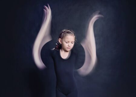 little girl angel with wings-arms on a dark backgroundの写真素材