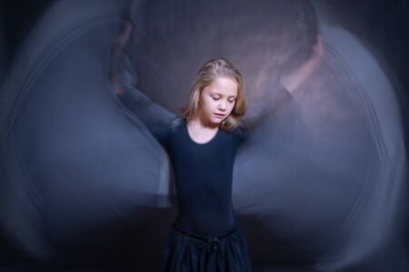 little girl angel with wings-arms on a dark backgroundの写真素材