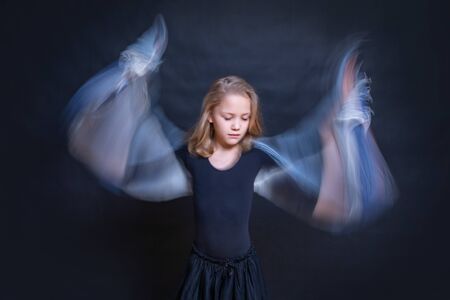 little girl angel with wings-arms on a dark backgroundの写真素材