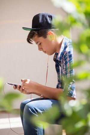 boy teenager playing with his gadgetの写真素材