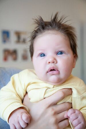 portrait of little one year old girl at home on hands parentの写真素材