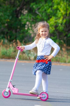 happy little girl on scooter in outdoorの写真素材
