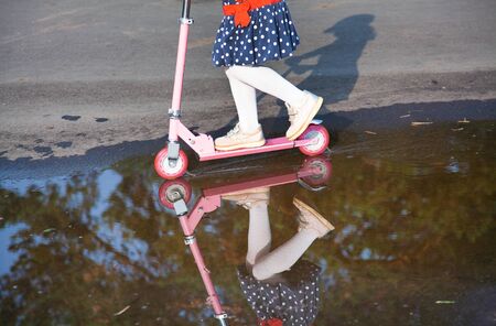 happy little girl on scooter in outdoorの写真素材
