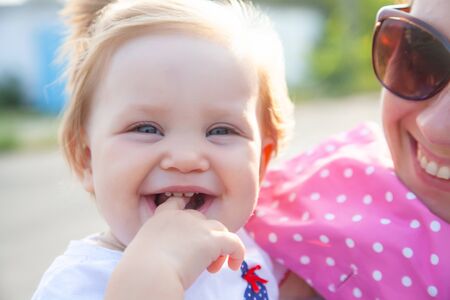 portrait of little one year old girl wit her mom outdoorの写真素材