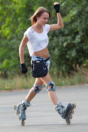 Beautiful teenage girl rollerskating in parkの写真素材