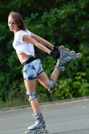 Beautiful teenage girl rollerskating in parkの写真素材
