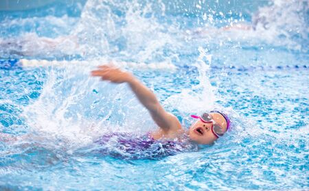little girl swimming in the pool at the training in swimming