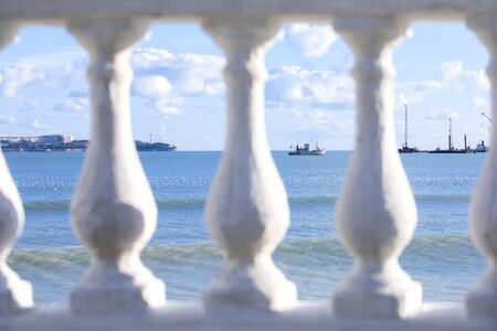 seascape through the frame of the white stone fence of the promenade