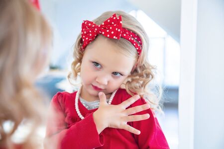 portrait of a little cute ladies fashionista front on mirrorの写真素材
