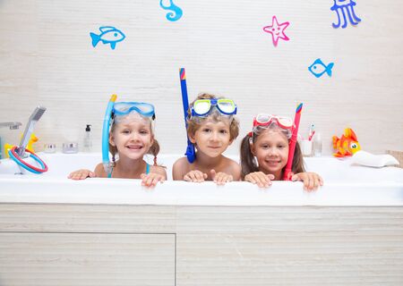 funny children play in the bathroom instead of the beach on the sea because of the quarantine, due to the pandemic Covid-19の写真素材