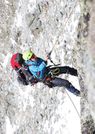 mountaineer woman descends from the mountain in the background of rocksの写真素材