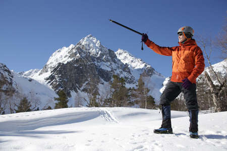 man mountaineer with ice ax climbs on the snowy mountainsの写真素材