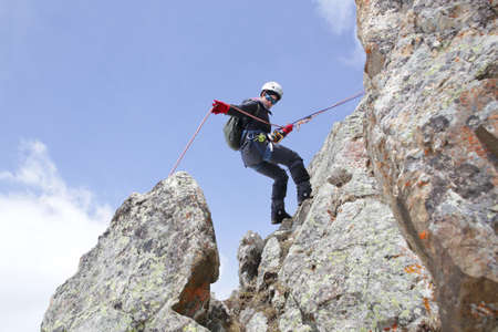 mountaineer woman descends from the mountain in the background of the landscape of snowy mountainsの写真素材