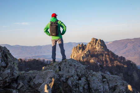 mountaineer on the top of a mountain in the background of the landscape of mountainsの写真素材