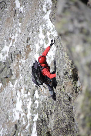 man mountaineer with ice ax climbs on the snowy mountainsの写真素材