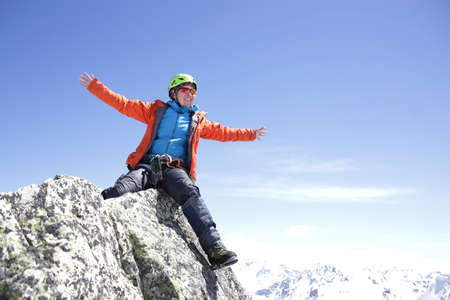 climber woman climbs into the mountains against the backdrop of the landscape of snowy mountainsの写真素材