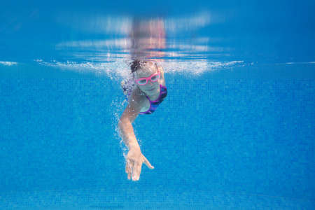 teens girl swimming in pool. under water photo,の写真素材
